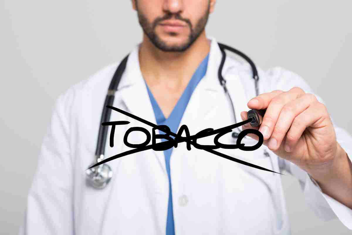 un medico cancella la scritta tobacco da un vetro