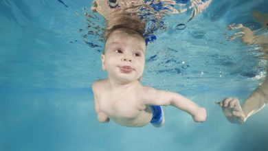 un neonato nuota sott'acqua in una piscina
