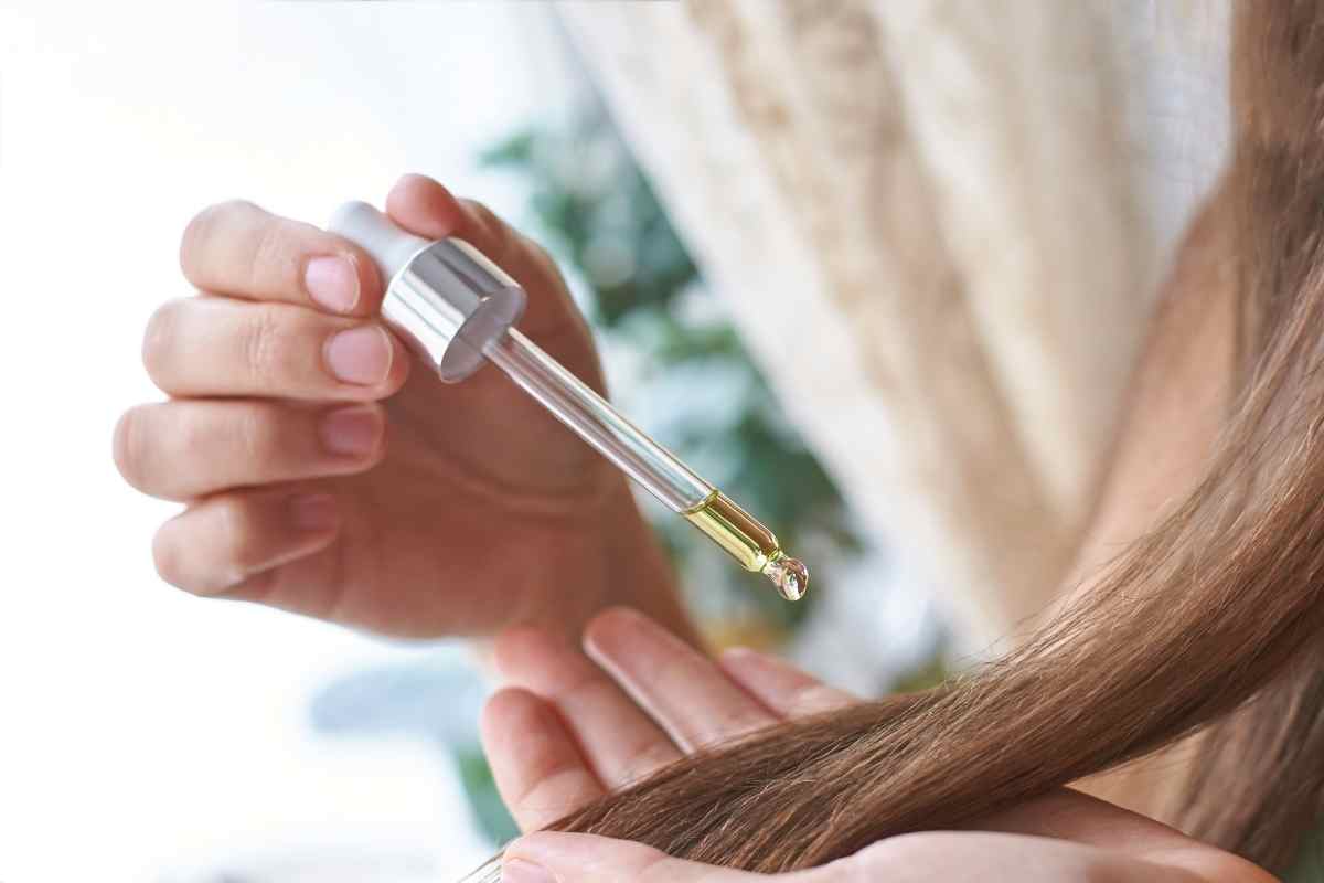 una donna si mette delle gocce di cheratina sui capelli