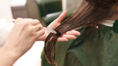 una parrucchiera mette la cheratina sui capelli di una cliente