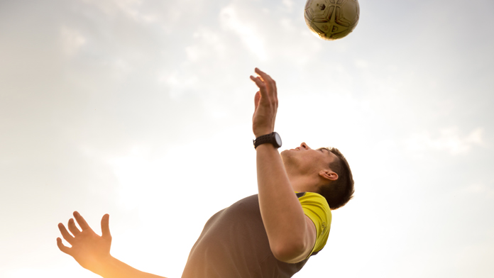 un calciatore si prepara a colpire di testa il pallone