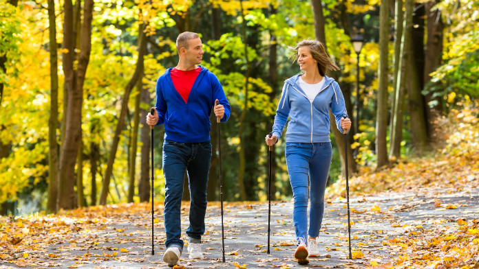 Un ragazzo e una ragazza praticano Nordic Walking in un bosco