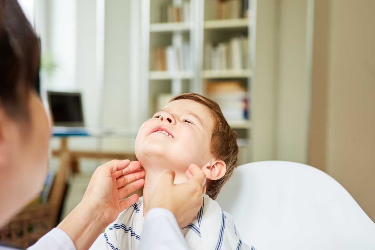 un medico controlla i linfonodi al collo di un bambino
