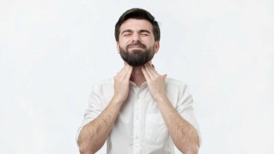 un uomo si palpa i linfonodi del collo