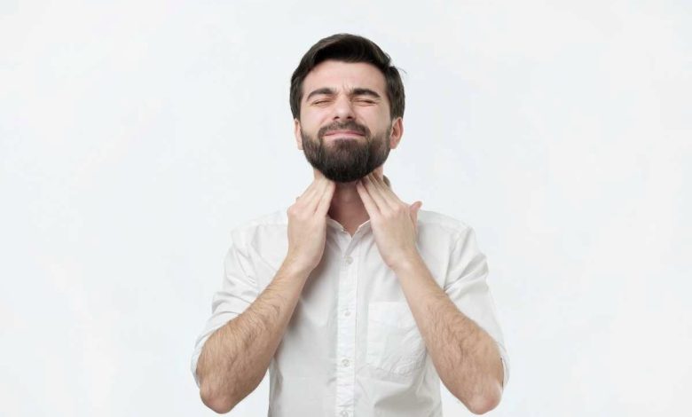 un uomo si palpa i linfonodi del collo