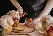 una signora prepara delle conserve in casa