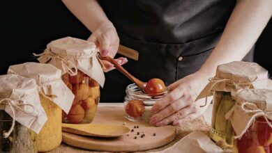 una signora prepara delle conserve in casa