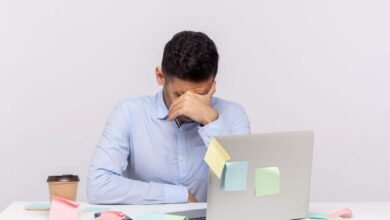 un uomo al lavoro davanti al pc sopraffatto
