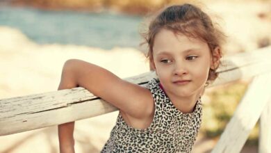 una bambina in spiaggia con un abito animalier