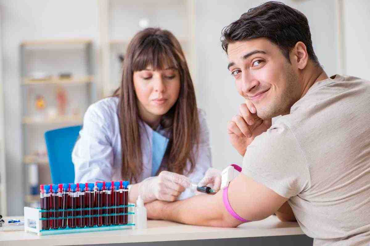 una infermiera esegue un esame del sangue a un paziente sorridente 