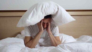 un uomo a letto distrutto da una notte insonne