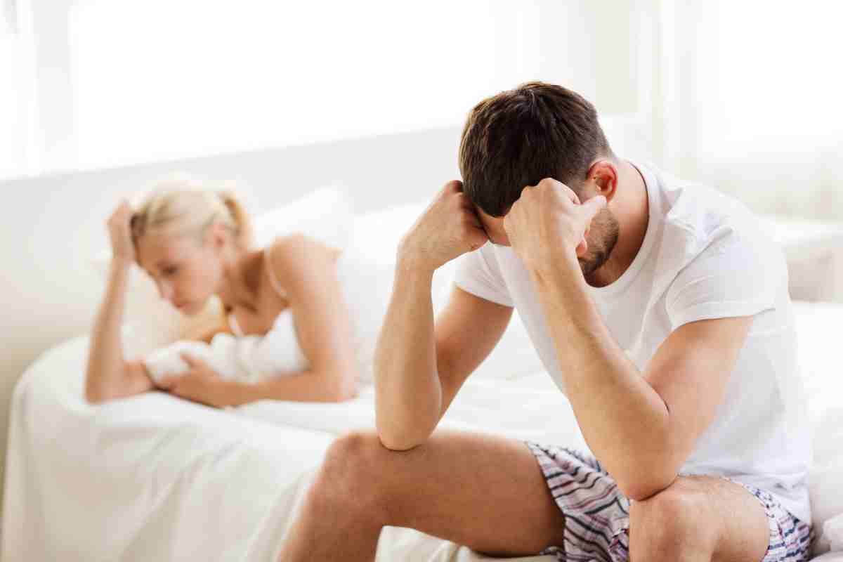 un uomo triste sul letto accanto a una ragazza