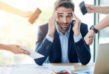 uomo d'affari stressato circondato da persone che gli mostrano device elettronici
