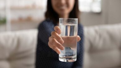 una ragazza offre un bicchiere di acqua