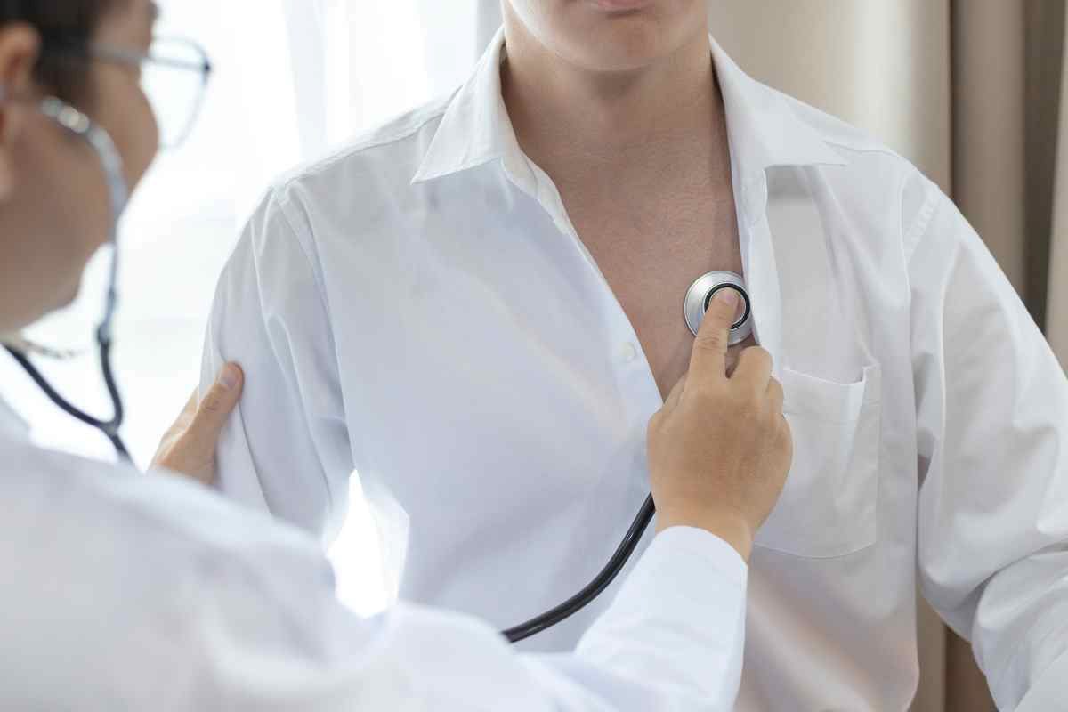 un medico ausculta il cuore di un paziente