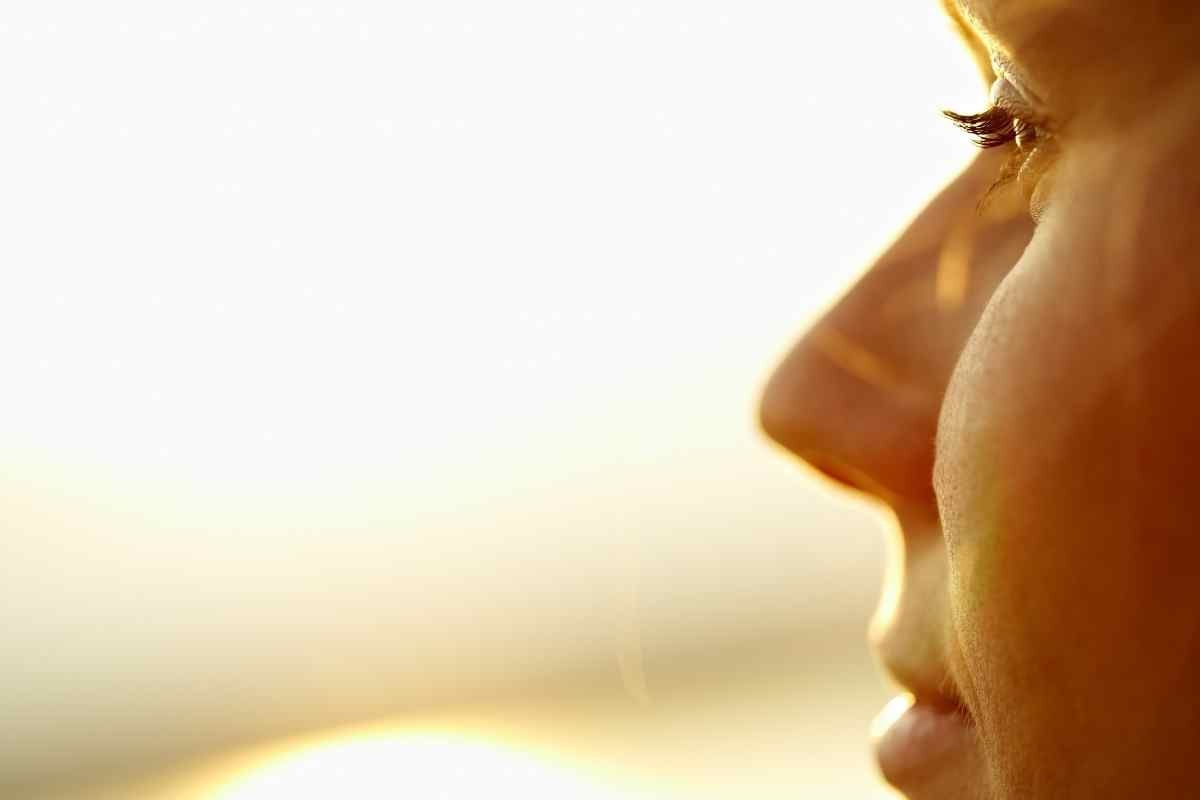 una donna guarda la luce solare al mare
