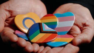 due mani con le diverse bandiere della comunità lgbtqi