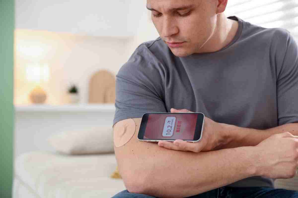 un ragazzo controlla attraverso un'app la sua glicemia