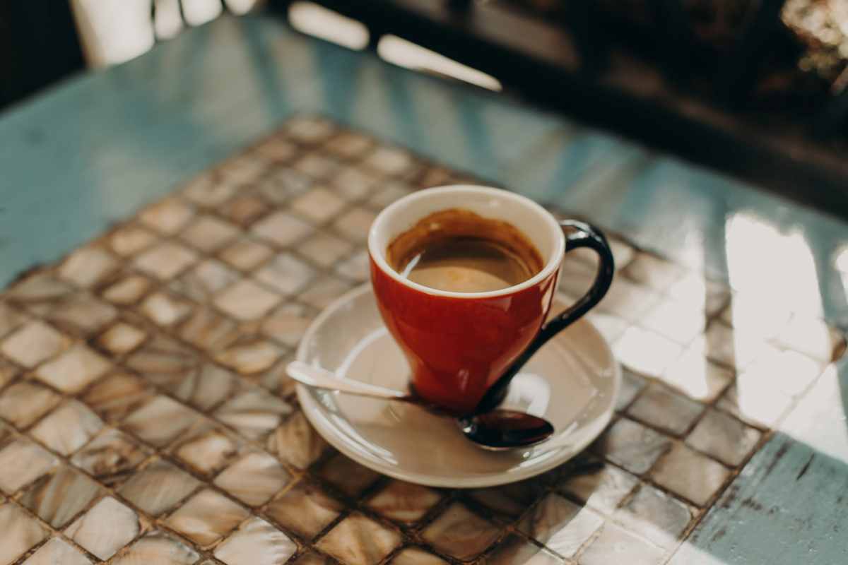 Tazza di caffè nero su un tavolo in un caffè all’aperto
