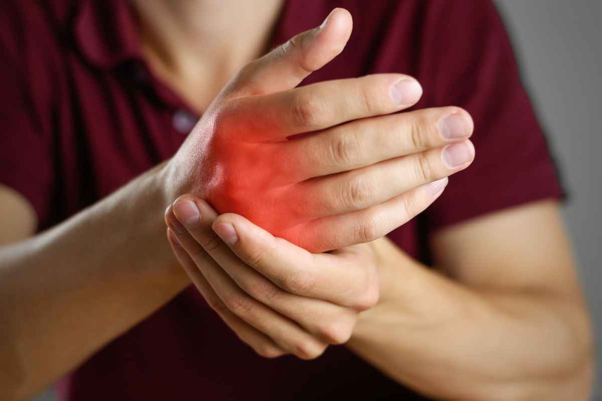 una donna si massaggia la mano dolorante
