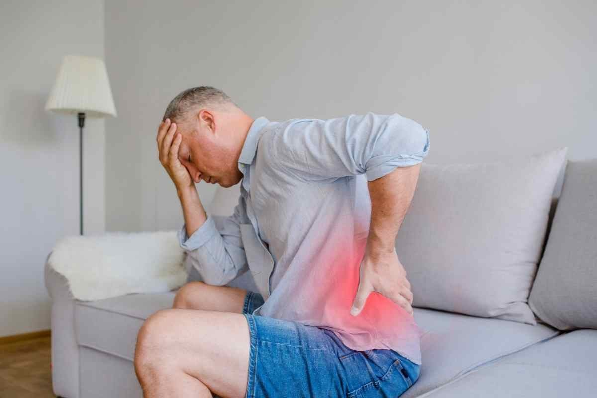 un uomo si massaggia la schiena