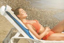 donna sul lettino in spiaggia che prende il sole