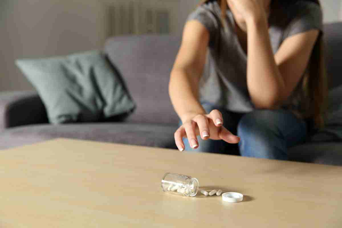una donna in evidente stato confusionale sta per prendere dei farmaci