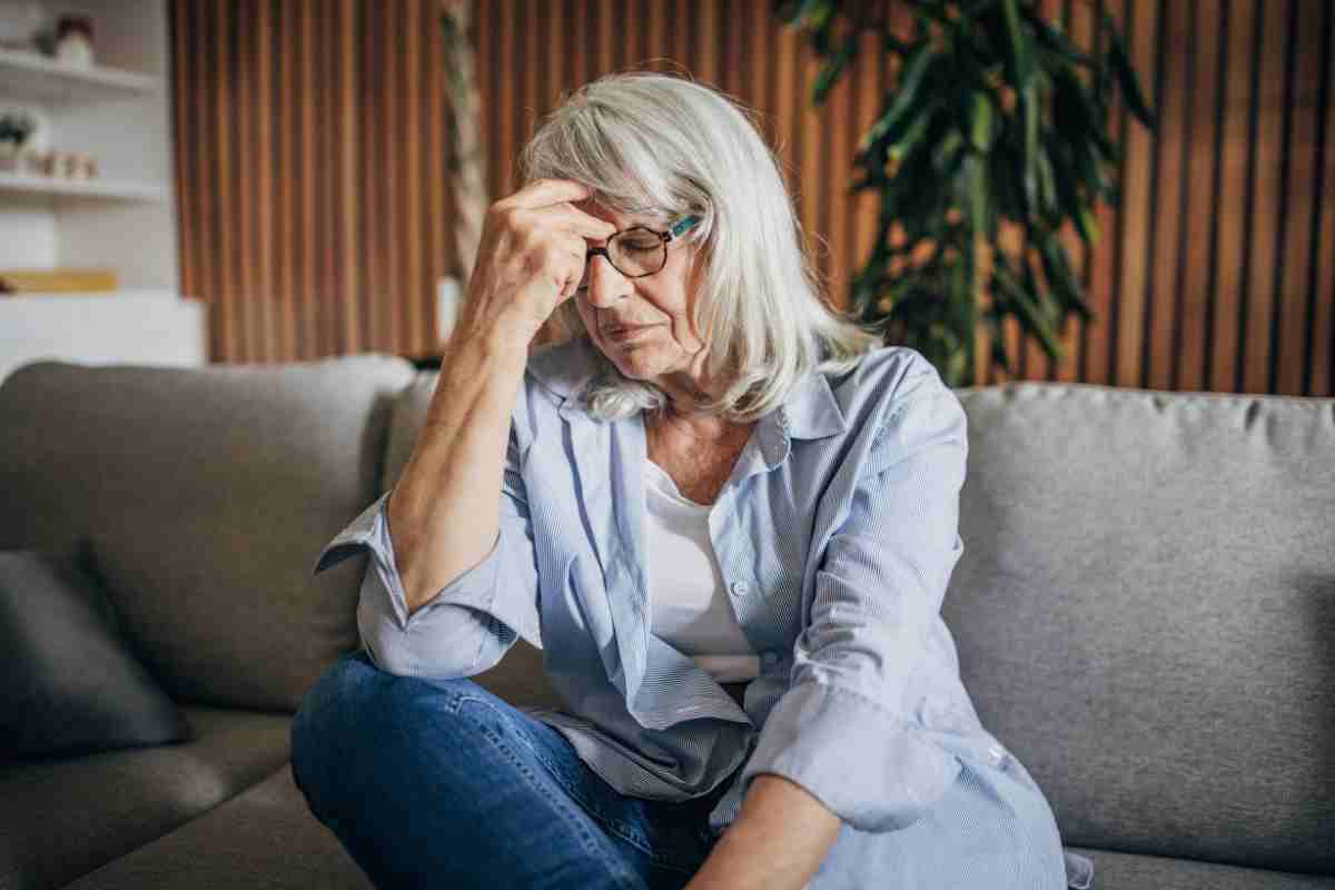 una donna sul divano di casa molto triste