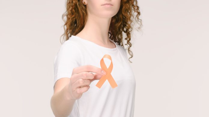 Una donna mostra il simbolo della ricerca contro la sclerosi multipla