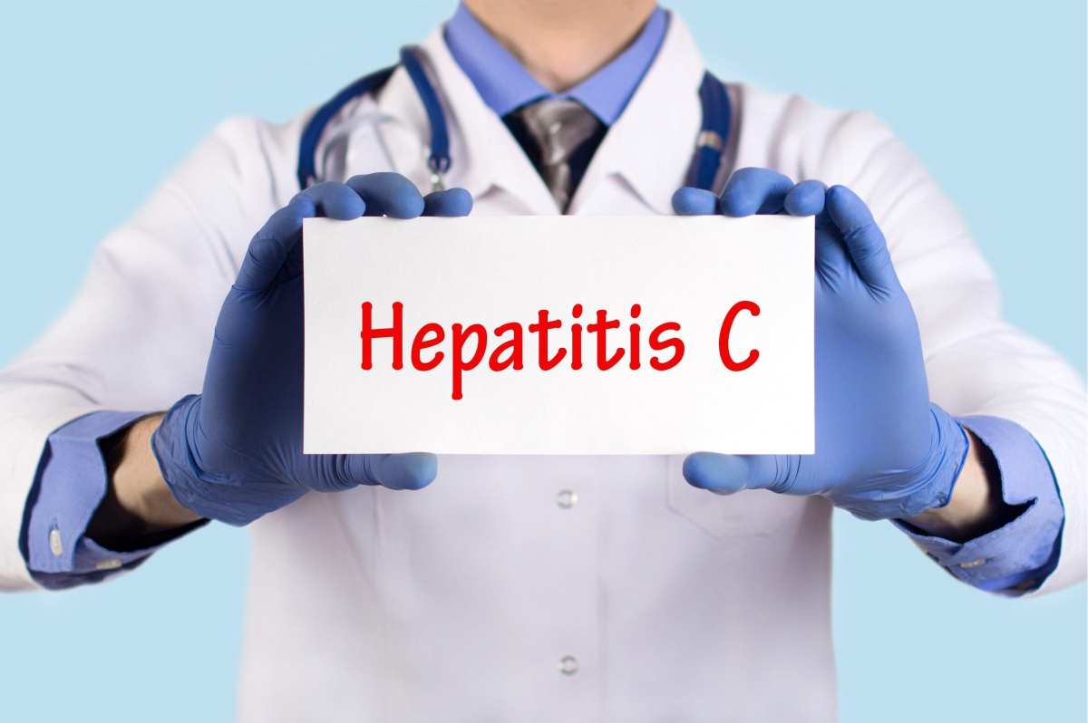 un medico tiene in mano un cartello con la scritta hepatitis c