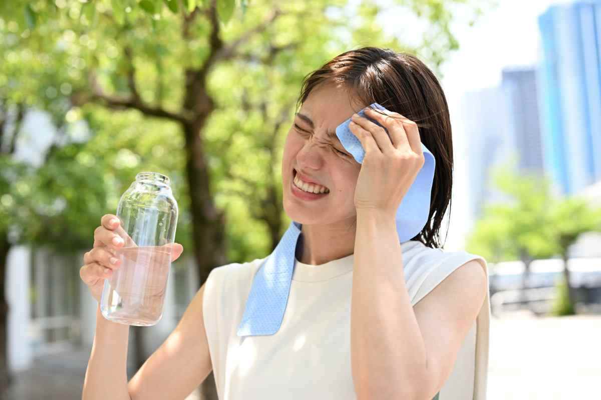 una ragazza si tampona con dell'acqua fresca la fronte
