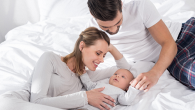 genitori con neonato sul letto coccole