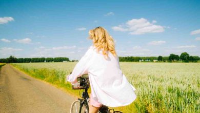 una ragazza pedala in campagna in un giorno estivo