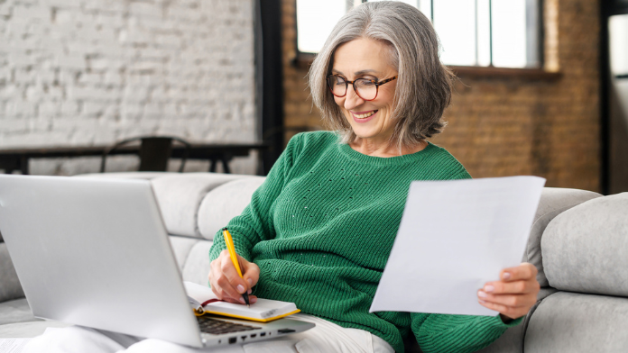 donna adulta che studia con appunti e computer