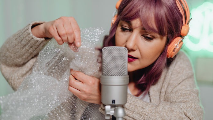 ragazza al microfono che registra suoni ASMR