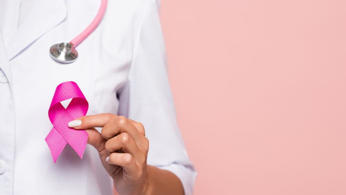 una dottoressa con il nastro rosa durante le visite senologiche gratuite