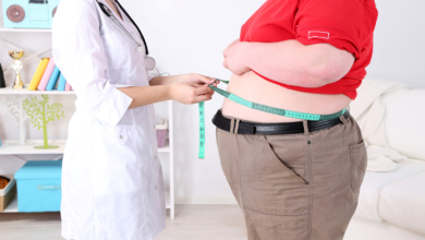 un medico misura il girovita di un paziente obeso