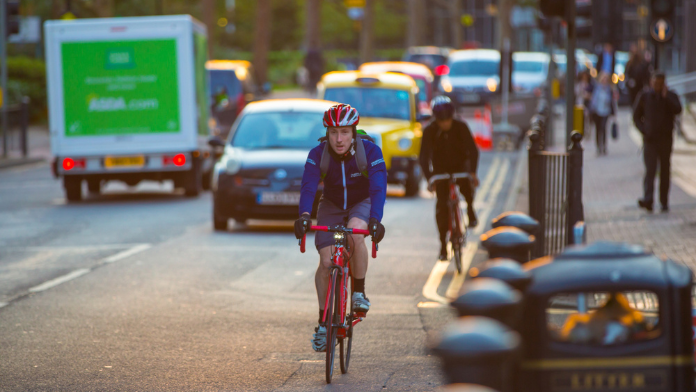 ciclisti e pedoni in mezzo all'inquinamento cittadino