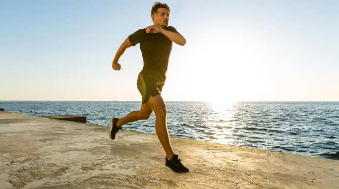 Un uomo corre sulla spiaggia