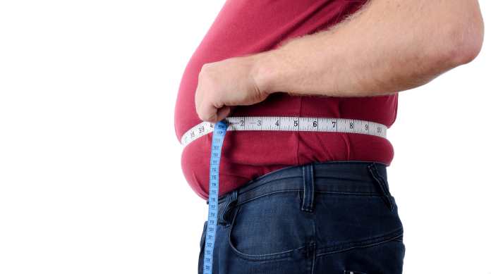 un uomo in sovrappeso si misura il girovita