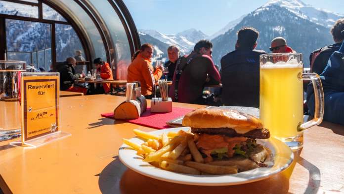 Un cheeseburger con una birra media in montagna