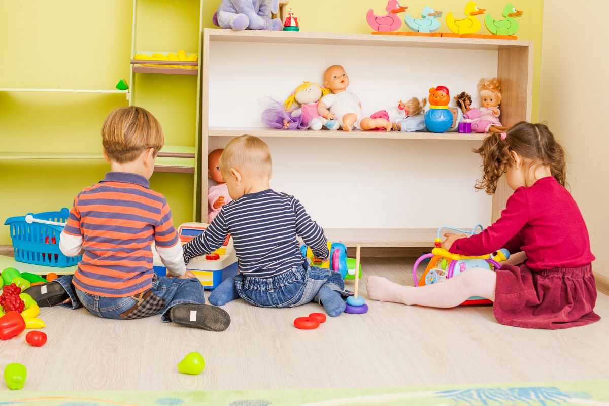 bambini di spalle che giocano all'asilo