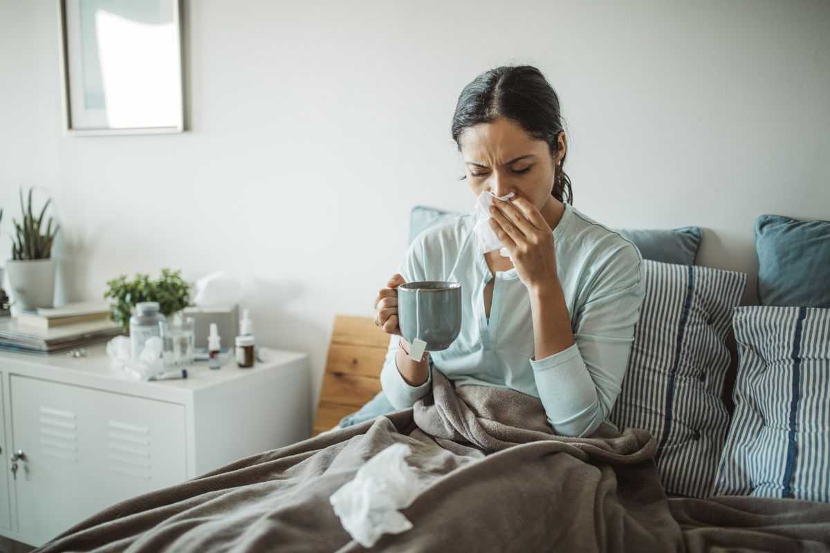 donna a letto con sintomi iniziali del morbillo simili a quelli dell'influenza