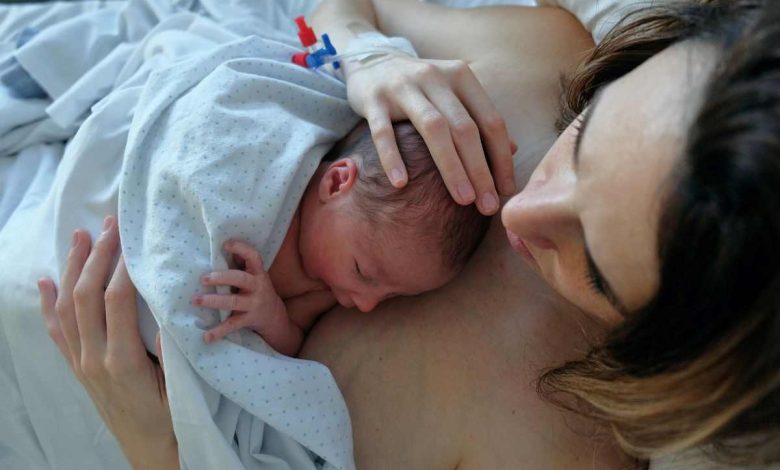 donna che ha appena partorito con neonato appoggiato sul suo torace nudo