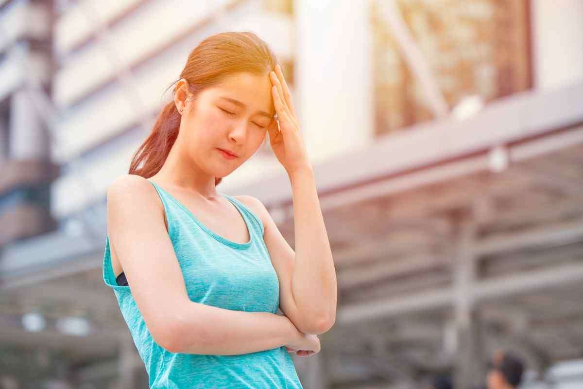 una donna con mal di testa sotto il sole