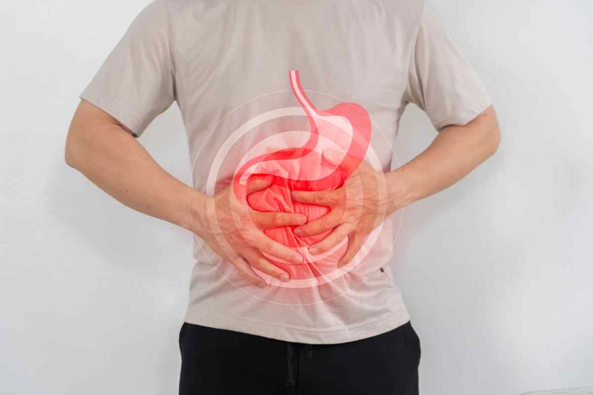 foto con IA un uomo mette le mani su intestino e stomaco