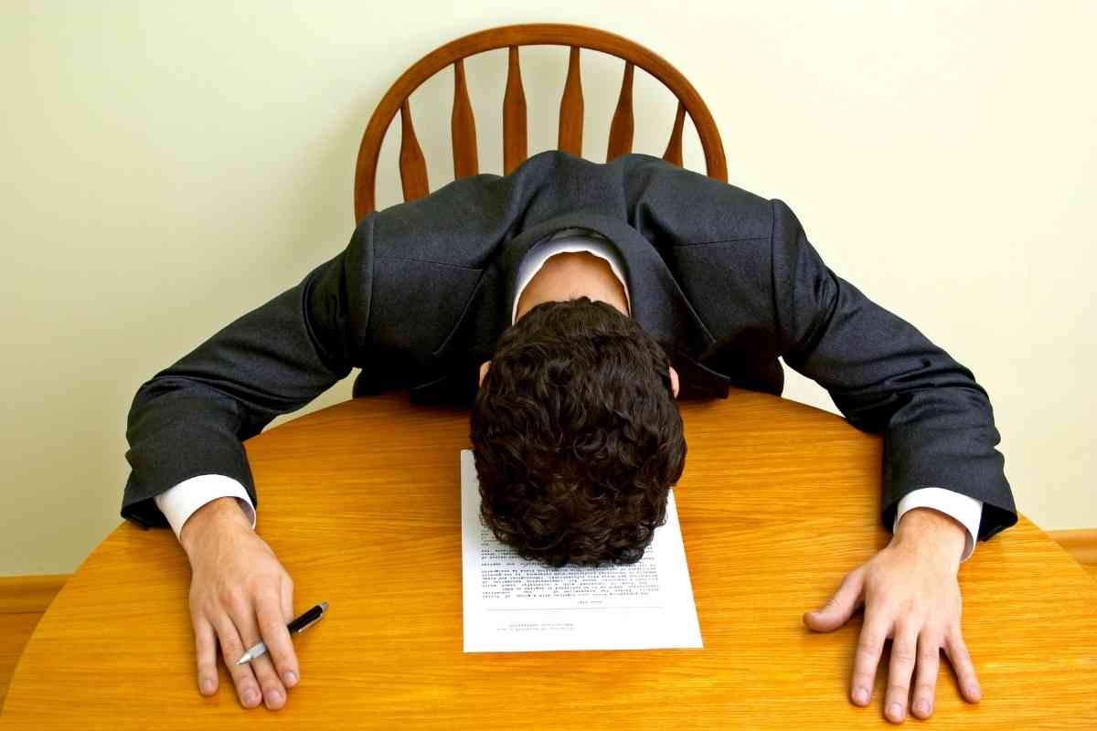 un uomo colto da un colpo di sonno al lavoro