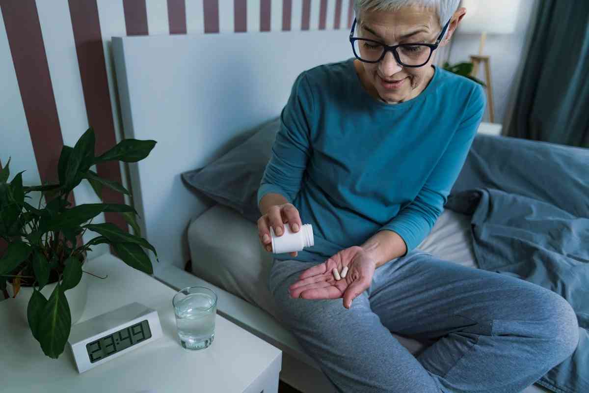 una donna assume un integratore di melatonina prima di andare a dormire
