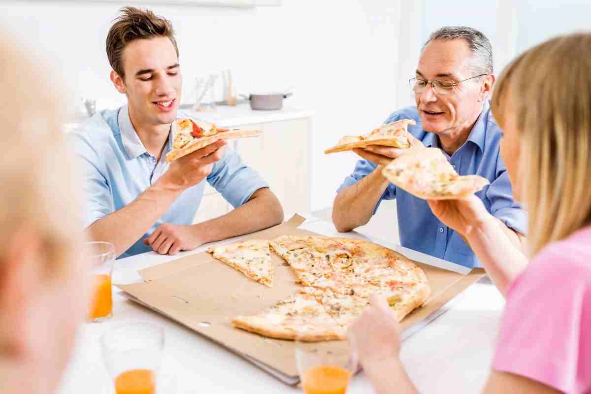 una famiglia mangia una pizza a pranzo