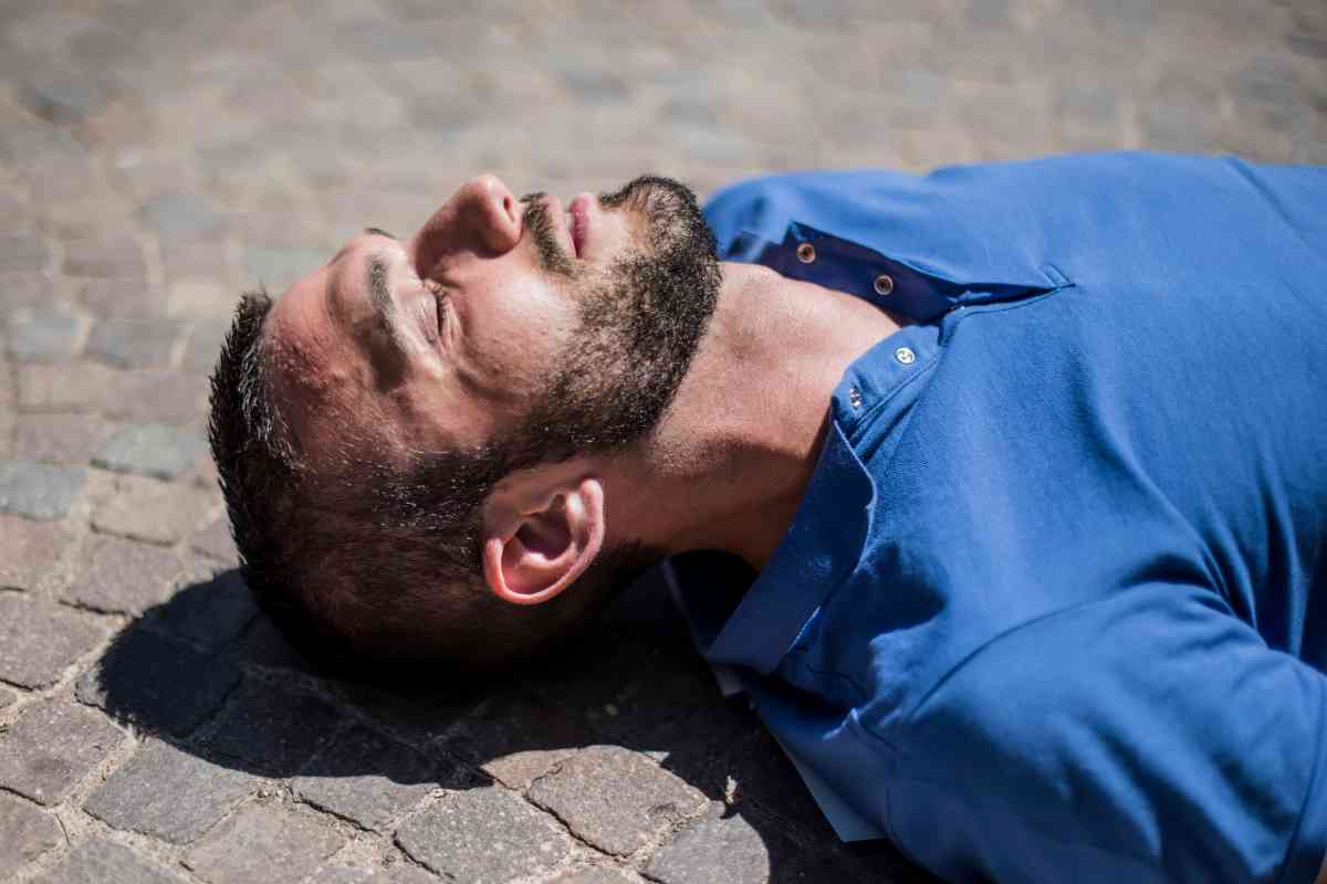 un uomo svenuto a terra per il caldo